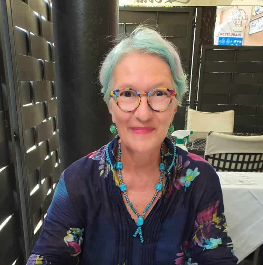 Lidija Arambašić wearing colorful glasses and jewelry, smiling outdoors.